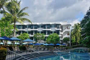 A hotel with a swimming pool, multiple balconies, and outdoor umbrellas. - Holiday Style Ao Nang Beach Resort Krabi (Krabi)