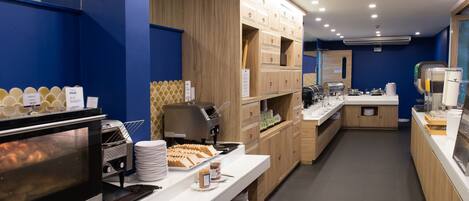 A modern breakfast area with a self-service station, a coffee machine, and a buffet counter.