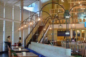 A spacious indoor area with seating arrangements, a staircase, and a high ceiling with exposed beams. - Holiday Style Ao Nang Beach Resort Krabi (Krabi)