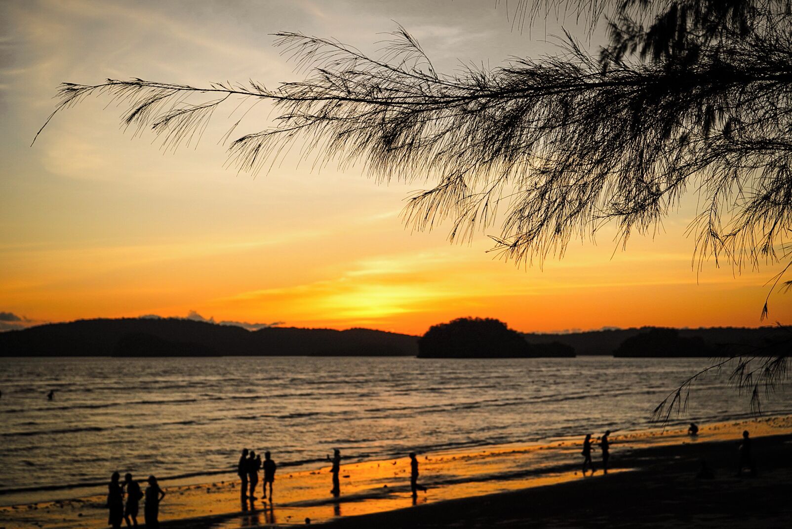 Perto da praia, areia branca, guarda-sóis, toalhas de praia 