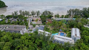 Vista aérea de un resort con varias edificaciones, una piscina y una playa.