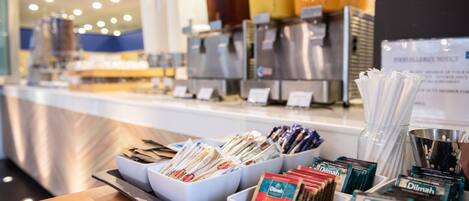 A coffee station with various coffee pods and a coffee machine in the background.