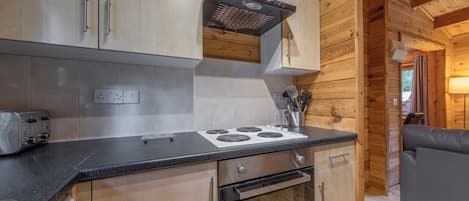 Une cuisine avec des meubles de rangement en bois, une cuisinière, un four et un grille-pain.