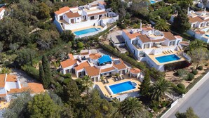 A residential area with multiple houses, each featuring a swimming pool and surrounded by lush greenery. - Casa Sonny - villa with airco and pool near golf course, beaches and town (Carvoeiro)