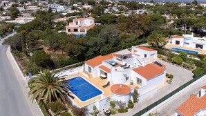 A residential area with houses, a swimming pool, and a road. - Wonderful holiday villa with airco, heatable pool + jacuzzi on golf development (Carvoeiro)
