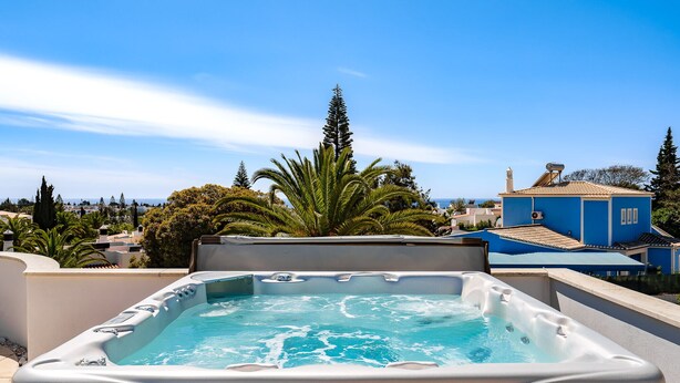 A hot tub on a rooftop with a clear view of the surrounding buildings and trees. - Wonderful holiday villa with airco, heatable pool + jacuzzi on golf development (Carvoeiro)