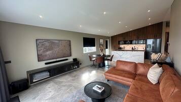 Appartement Deluxe | Coin séjour | TV connectée de 75 pouces avec chaînes numériques, télévision, iPad