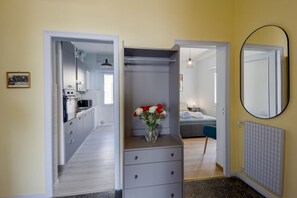 A bedroom with a bed, a dresser, a mirror, and a vase of flowers.