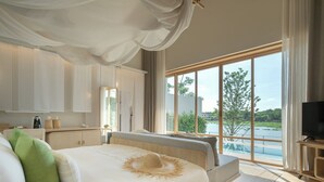 Un dormitorio con una cama grande, televisión y vista a un lago.
