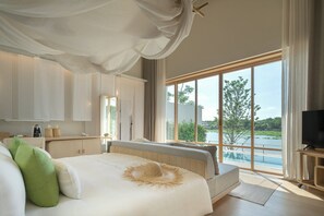 Un dormitorio con una cama grande, televisión y vista a un lago.