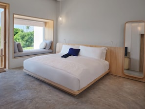 A modern bedroom with a large bed, a window seat, a mirror, and a view of greenery. - sala bang pa-in, a Member of Design Hotels (Bang Pa-in)