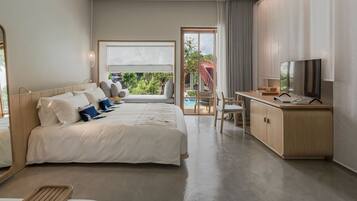 Ein Hotelzimmer mit Bett, Schreibtisch mit Fernseher und Blick ins Freie.