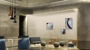 A modern lobby with a curved ceiling, a reception desk, seating area, and abstract wall art. - Ibis Styles Semarang Simpang Lima (Semarang)