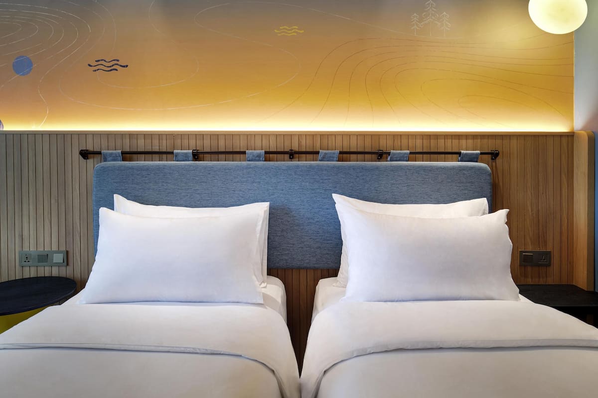 A double bed with a headboard, a bedside table, and a wall-mounted light fixture.