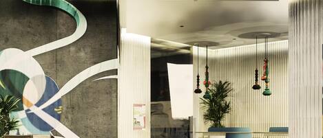 A modern lobby with a reception desk, seating area, and decorative elements.