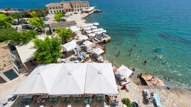 A coastal hotel with outdoor seating, a pool, and a view of the sea. - Mouragia Loft - Waterfront Old Corfu Town (Corfu)