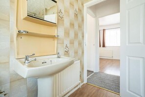 Un baño con lavamanos, espejo y azulejos decorativos.
