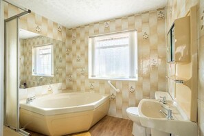 Un baño con bañera, lavamanos y ventana con vistas.