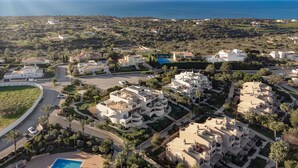 A coastal residential area with modern houses, a swimming pool, and a road curving through the landscape. - Casa Saudade, semidetached house with Jacuzzi near Ferragudo (Carvoeiro)