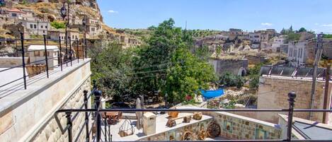 Una piscina en la azotea con vistas a una montaña rocosa y edificios tradicionales.