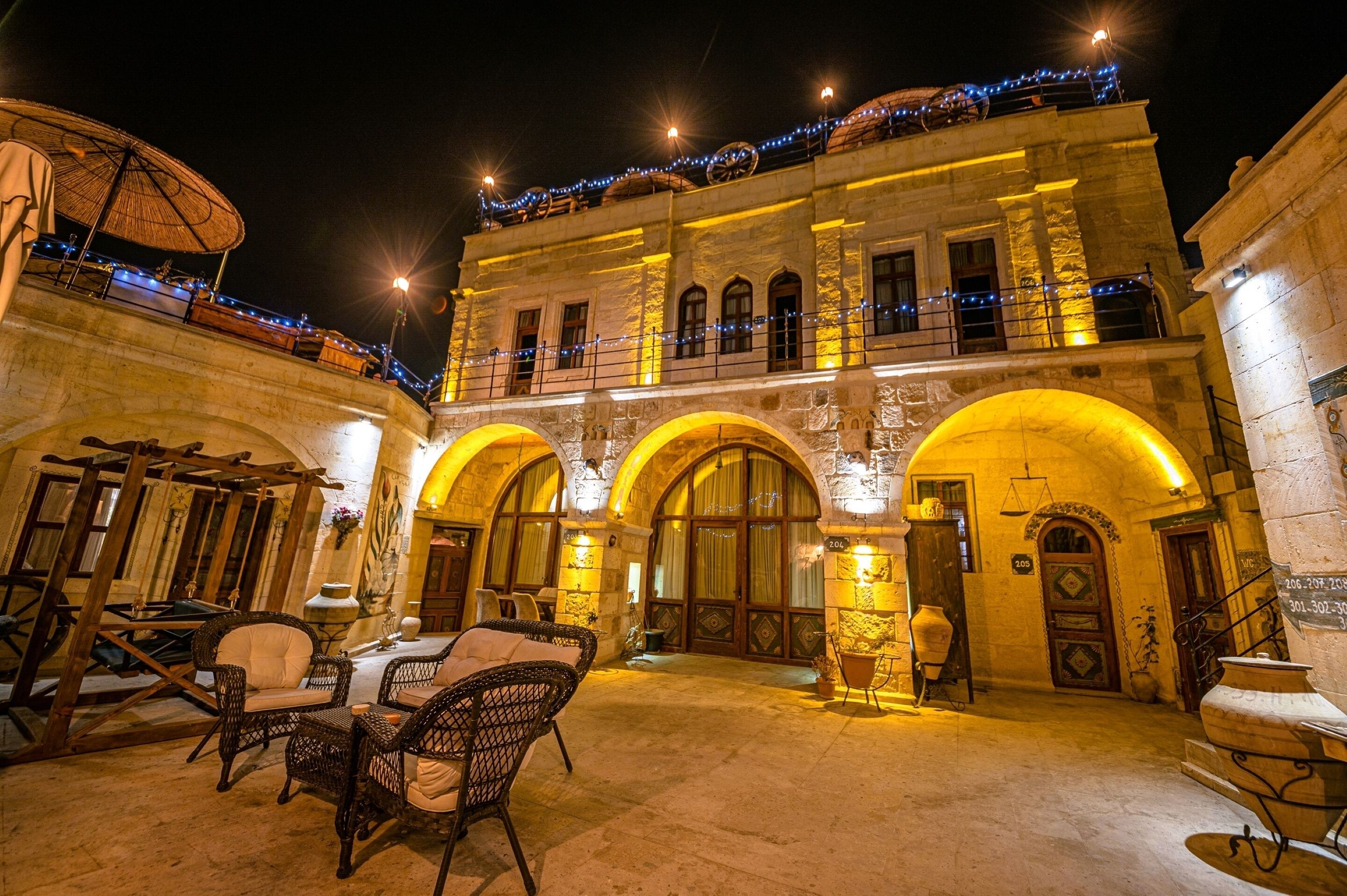 Un edificio histórico con arcos y un balcón decorado con luces colgantes.