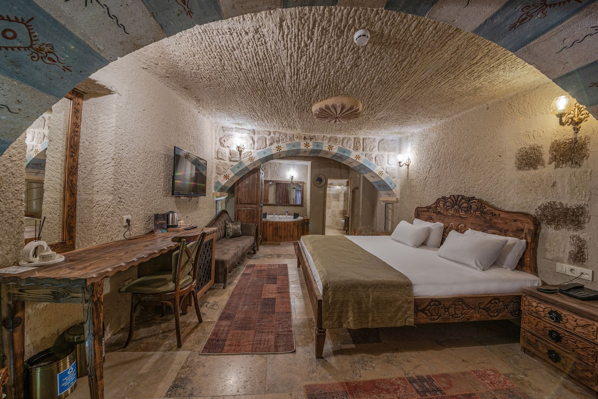 A rustic room with a wooden bed, a desk, and a chair.