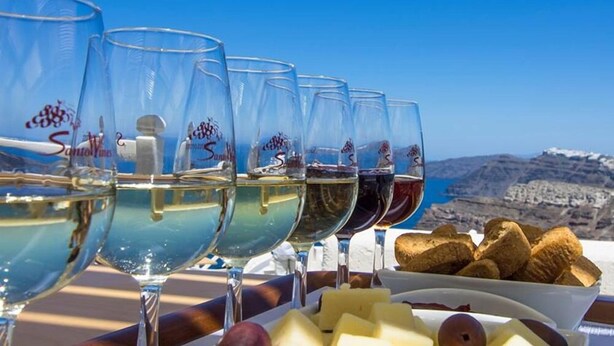 A table with wine glasses and cheese, overlooking a mountainous landscape. - Villa Mare Angelica (Santorini)