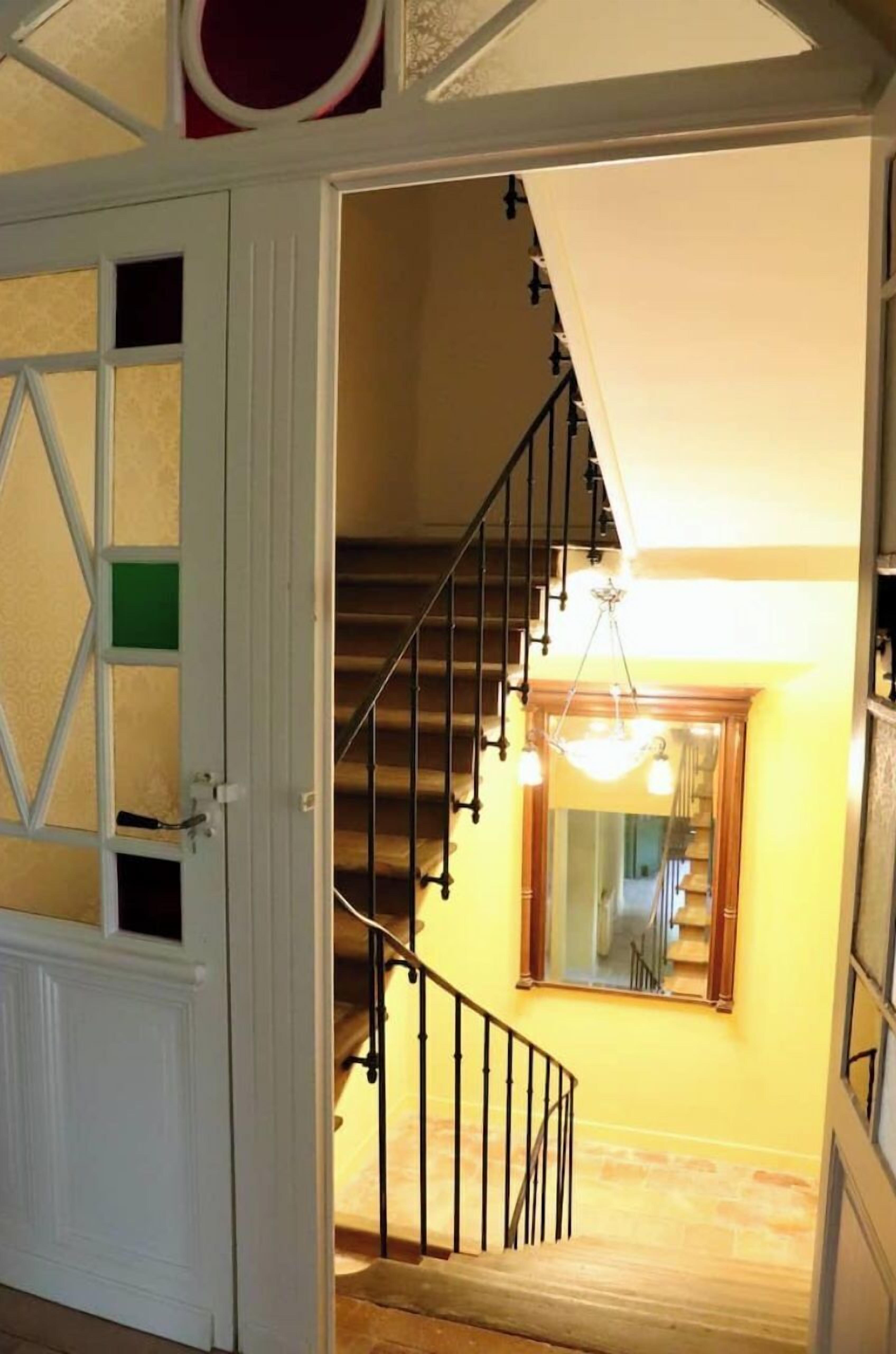 A staircase with a handrail and a light fixture above it.