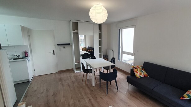 Ein moderner Wohnbereich mit Essplatz, einer Couch und einer Küchenzeile.