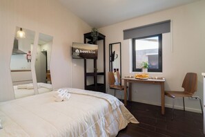 Relax in a stylish room with a made bed, desk, and flat-screen TV.
