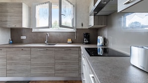 Una cocina moderna con una isla grande, electrodomésticos integrados y un ventanal con vistas.