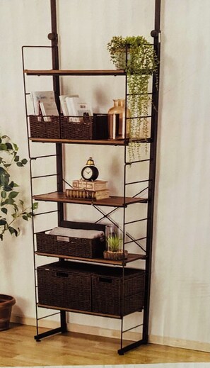 Storage and display space is available on this shelving unit, which holds books, decorative objects, and a clock.