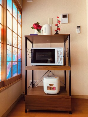 Kitchenette with microwave, rice cooker, and thermostat, offering a convenient cooking space with a view.