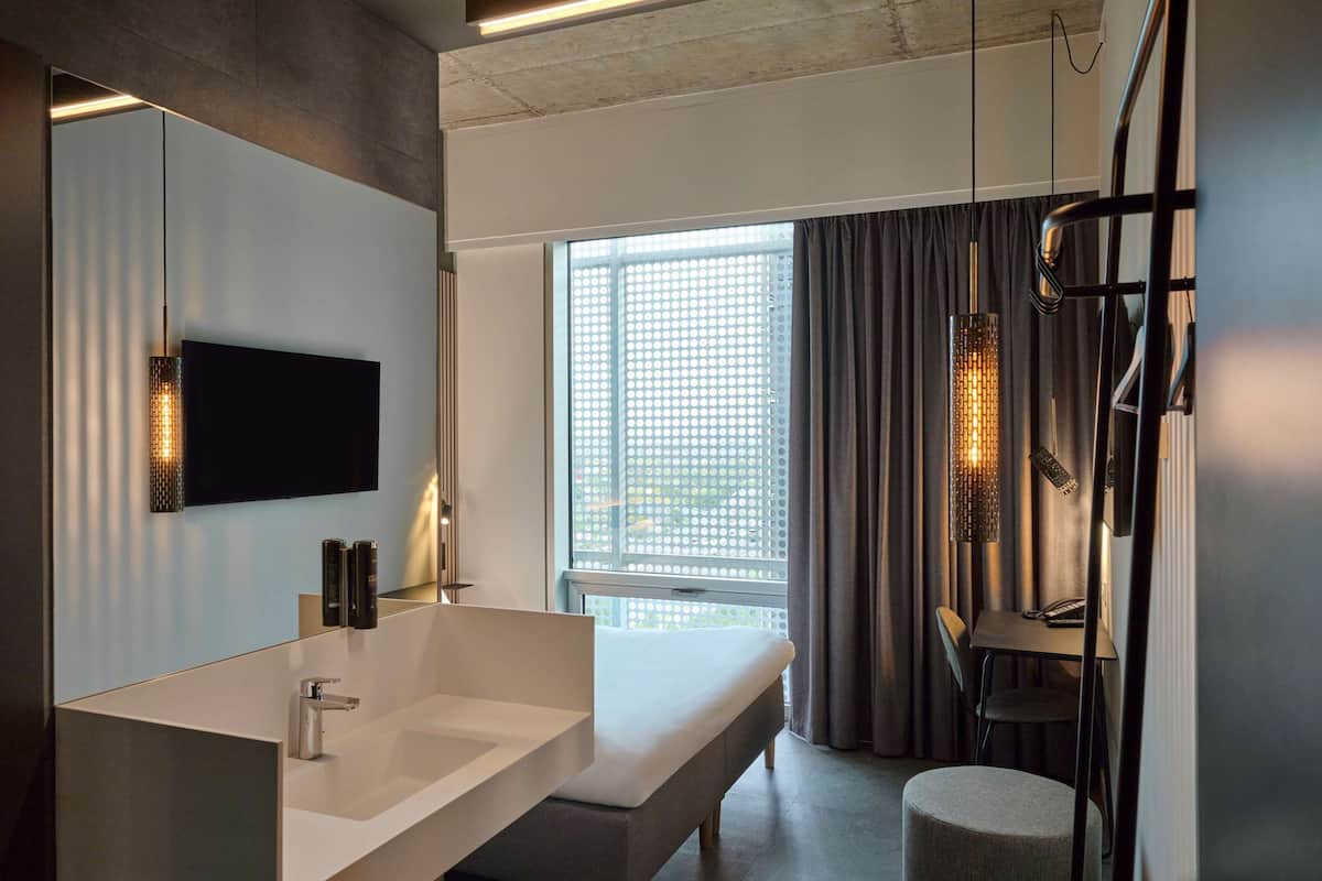 A modern bathroom with a large sink, mirror, and a shower area.