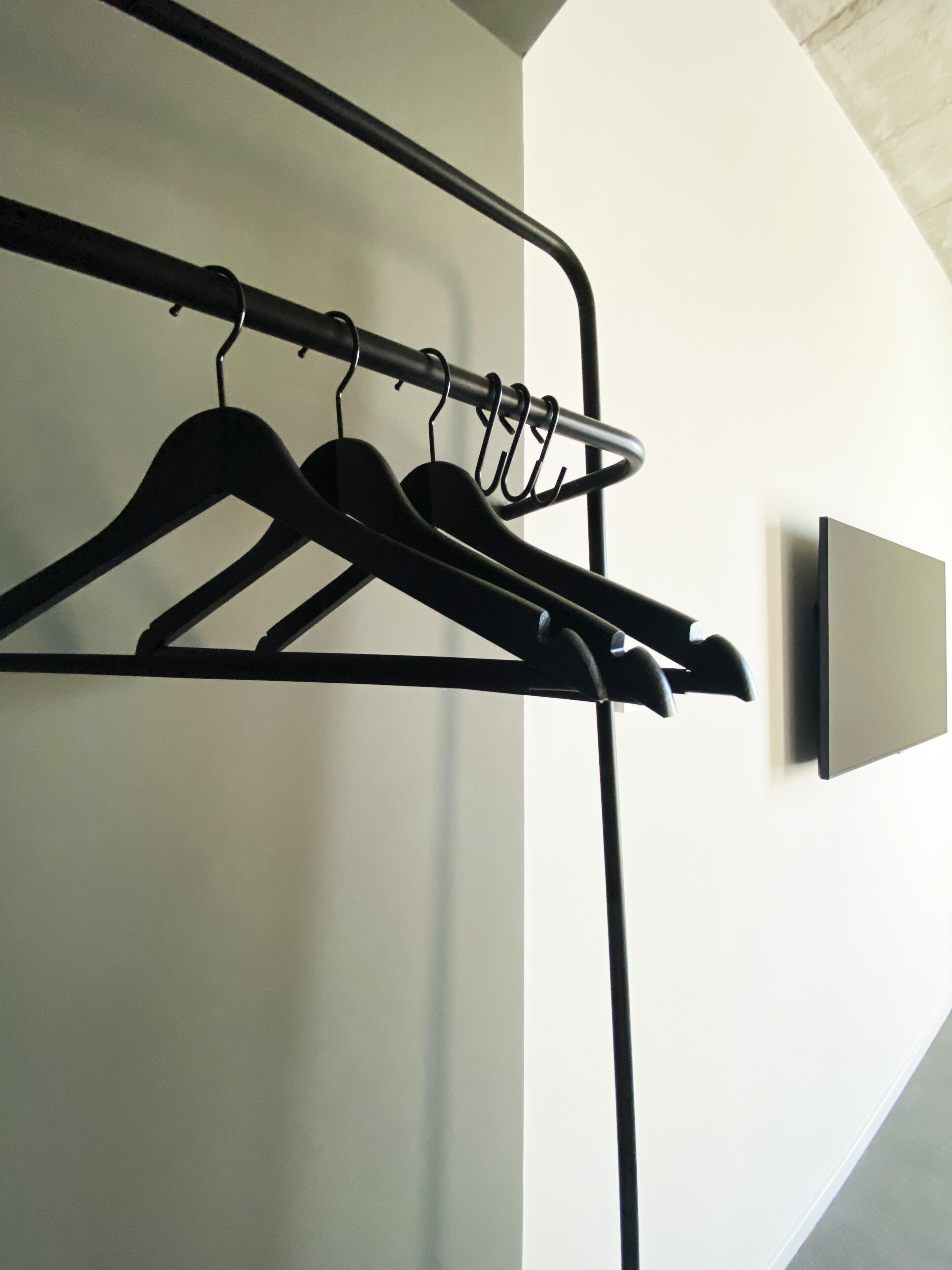 A wall-mounted coat rack with several hangers.