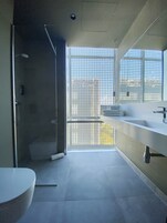 Ein modernes Badezimmer mit Duschkabine aus Glas, Toilette und Waschbecken mit Spiegel.