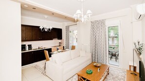 Una cocina moderna con armarios oscuros, un sofá blanco y una mesa de comedor con un centro de mesa verde.