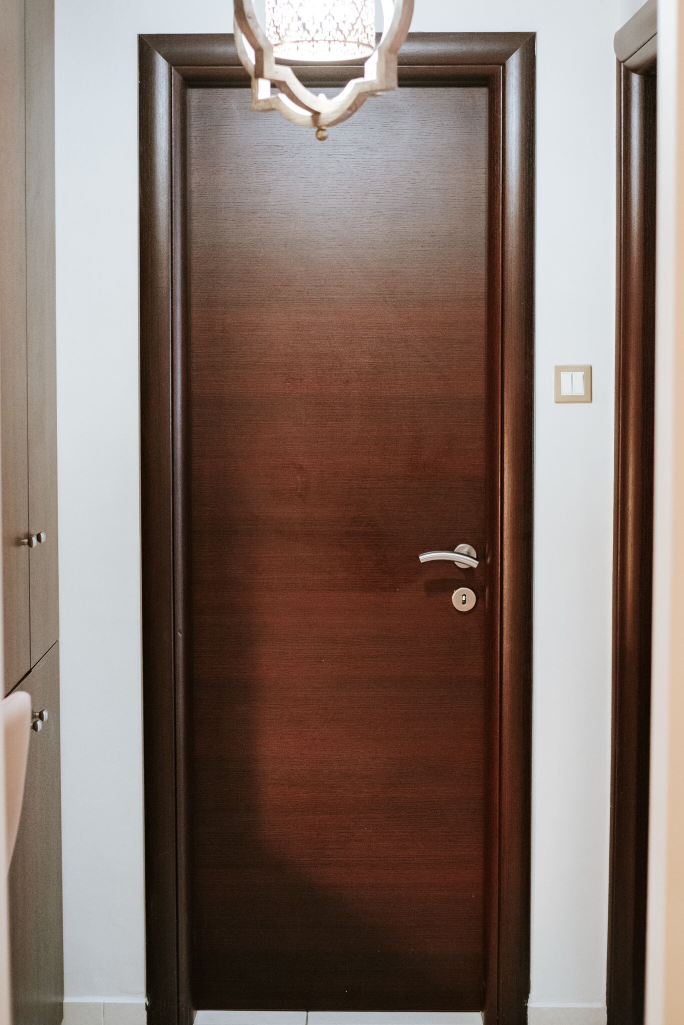 A closed wooden door with a keyhole and a door handle.