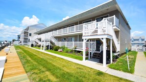 A two-story residential building with a wooden deck and a covered outdoor seating area. - Bridgepoint II 5D-Bayfront 94th St, Free WiFi, Pool, W/D, AC (Ocean City)