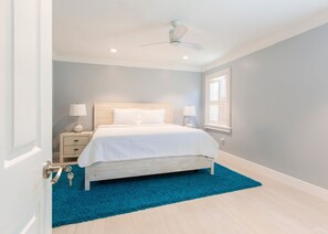 Cozy retreat with a single bed, bedside table, and lamp, set against a light grey backdrop.