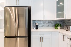 Enjoy cooking in this fully equipped kitchen with a refrigerator, cabinetry, and a backsplash.