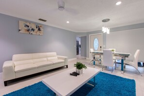 Relax in a stylish living room with a sofa, coffee table, and dining area.