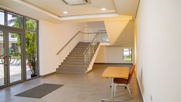 A spacious interior with a staircase, a desk, and a chair.