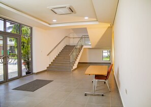 A spacious interior with a staircase, a desk, and a chair. - GENESIS JERSEY ESTATE (Port Harcourt)