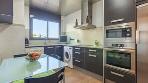 Eine moderne Küche mit Waschmaschine, Mikrowelle und Backofen.