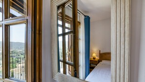A bedroom with a large window, a bed, and a nightstand with a lamp. - Villa "Castell Mirto" with Private Pool, Terraces & Wi-Fi (Calonge)