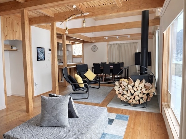 A spacious living area with a sofa, chairs, a dining table, and a fireplace.