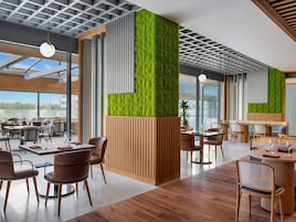Ein modernes Restaurant mit Holzböden, runden Tischen und Stühlen.