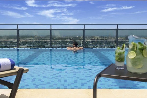 Una piscina al aire libre, sillones reclinables de piscina