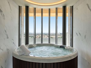 A hot tub with a view of a cityscape through large windows. - Swissotel Living Jeddah (Jeddah)
